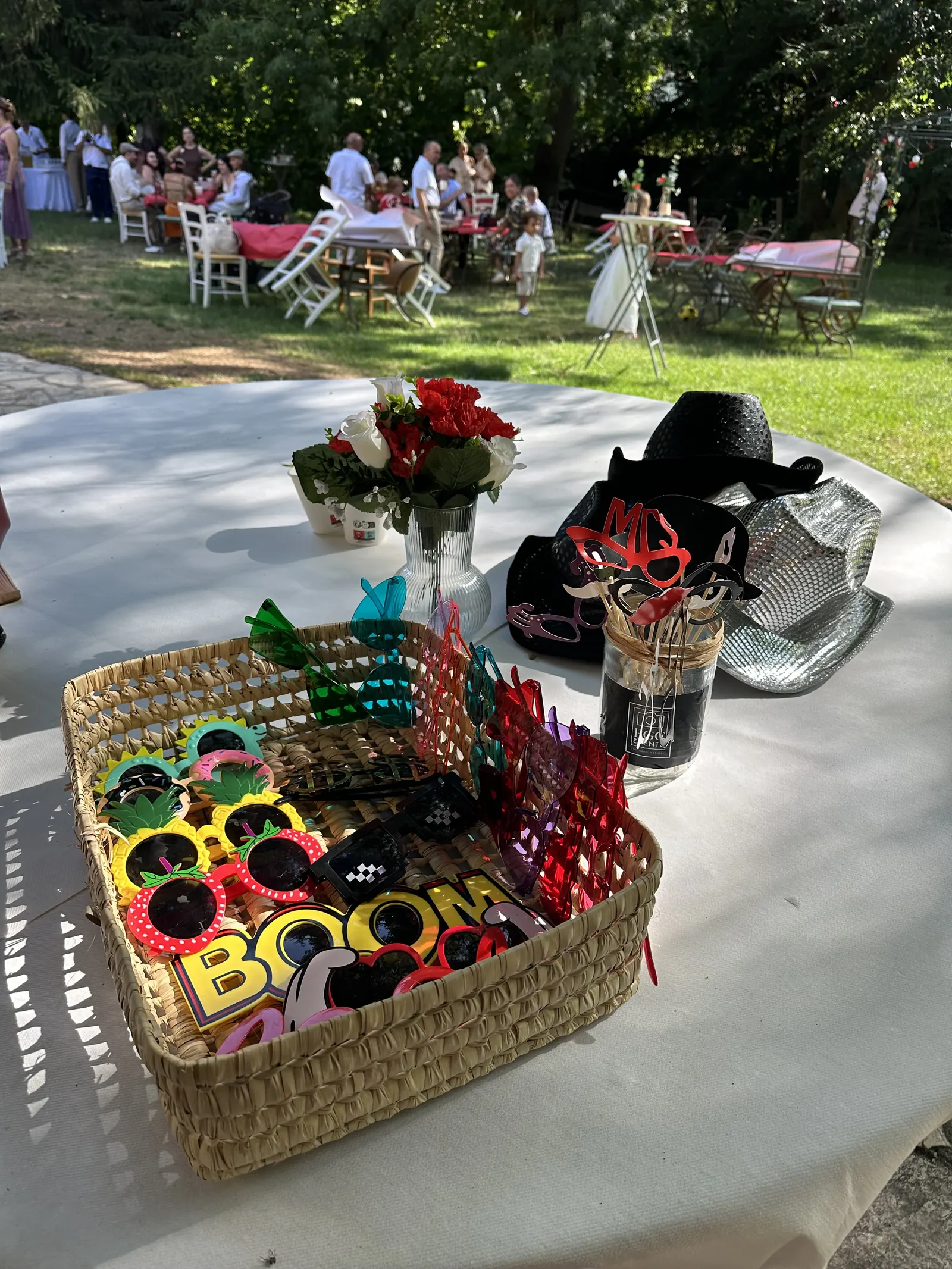Accessoires du photobooth sur une table lors d'un mariage en jardin