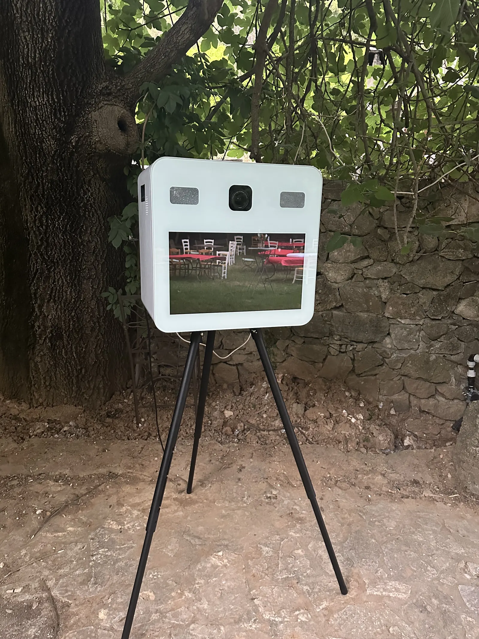 Photobooth EGC Events sous les arbres devant un mur en pierre